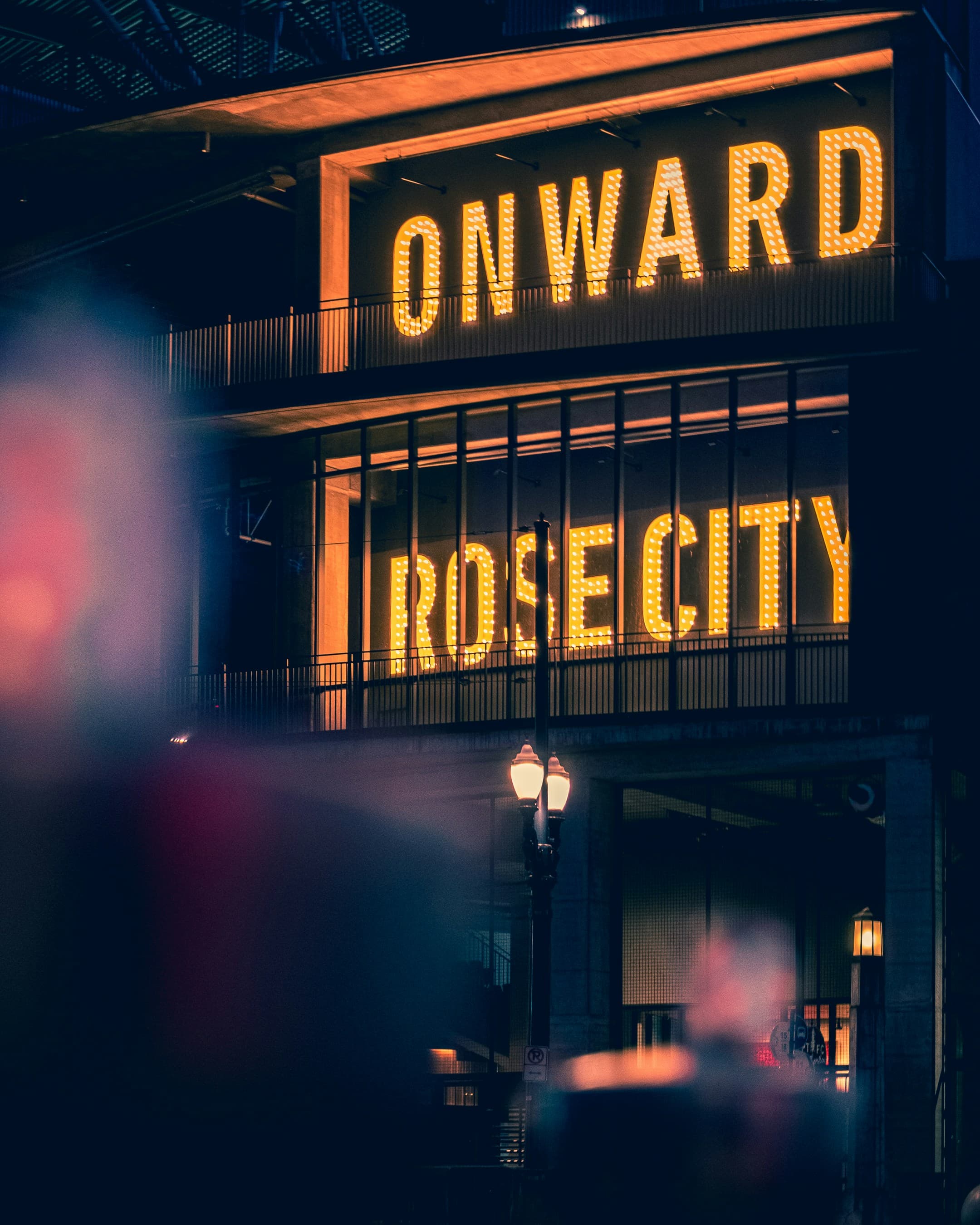 The lit-up 'Onward Rose City' rooftop sign in Portland at night