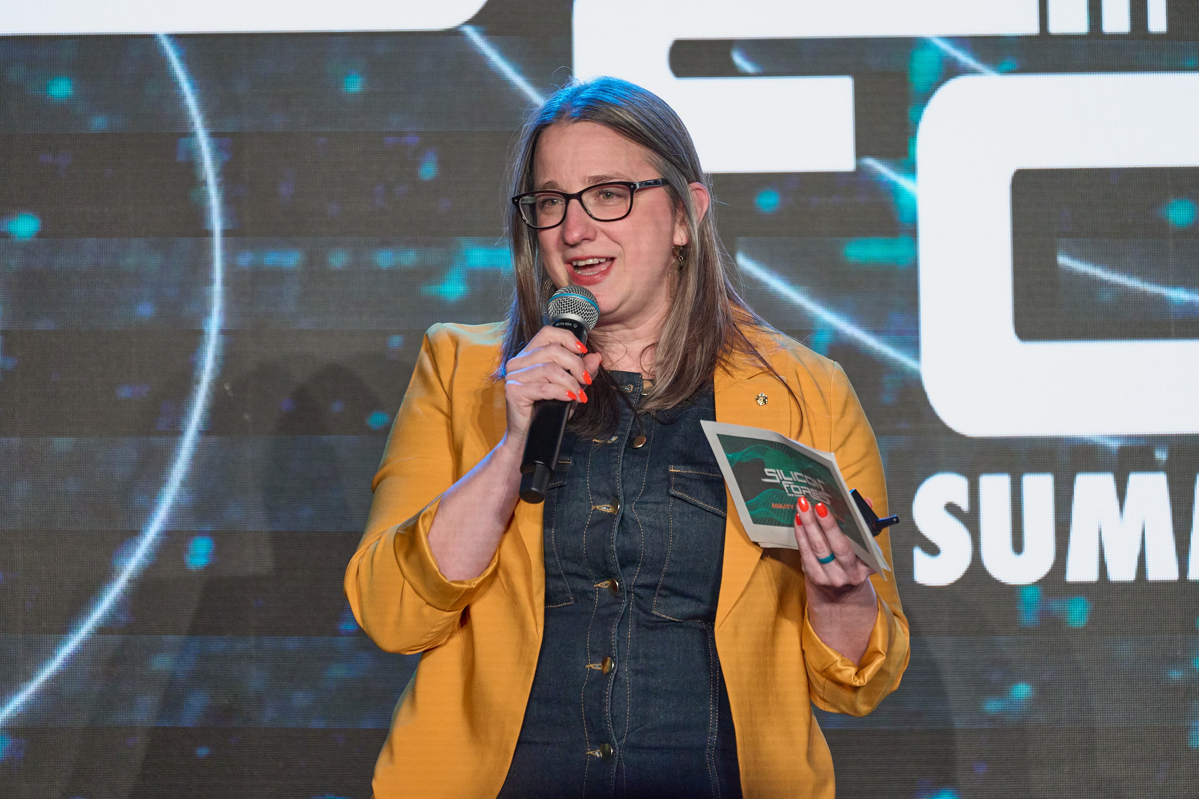 An AI Portland co-founder speaking into a microphone at the Silicon Forest Summit